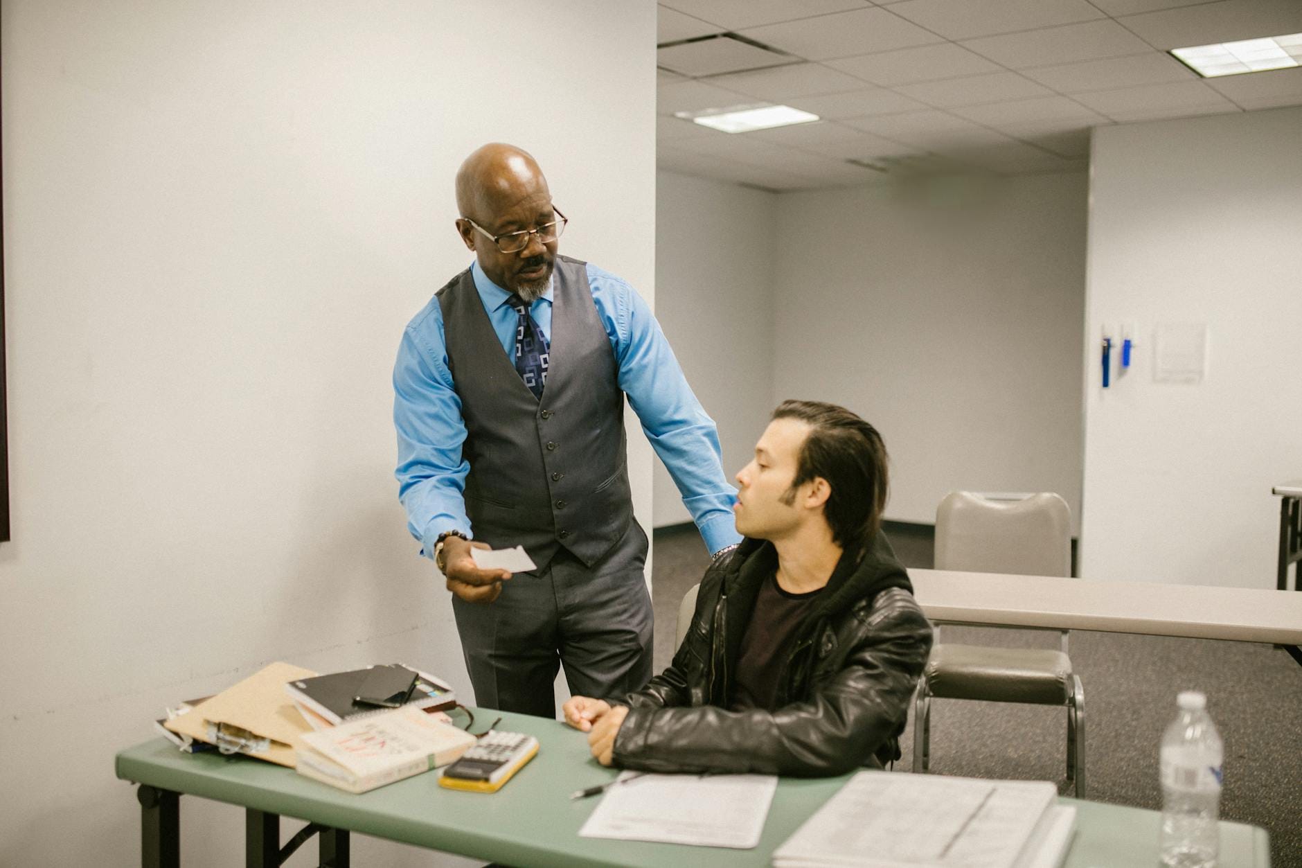 Nauczyciel rozmawia ze uczniem przyłapanym na ściąganiu podczas egzaminu